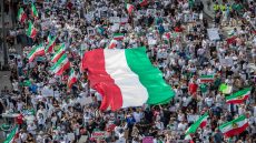TOPSHOT - Demonstrators hold Iran's flag during a protest for Mahsa Amini who died in custody of Iran's morality police, in Los Angeles, California, on October 1, 2022. Amini's death after her arrest by Iran's morality police has sparked a wave of unrest since the 22-year-old died on September 16 after her arrest for allegedly failing to observe Iran's strict dress code for women. The street violence has led to the deaths of dozens of people -- mostly protesters but also members of the security forces -- and hundreds of arrests. (Photo by Apu GOMES / AFP)